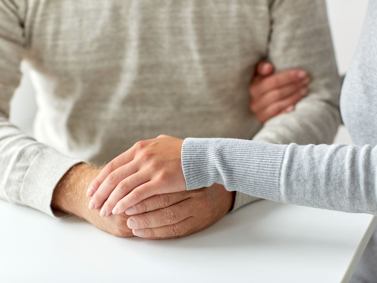 Deux mains se rassurant sur une table