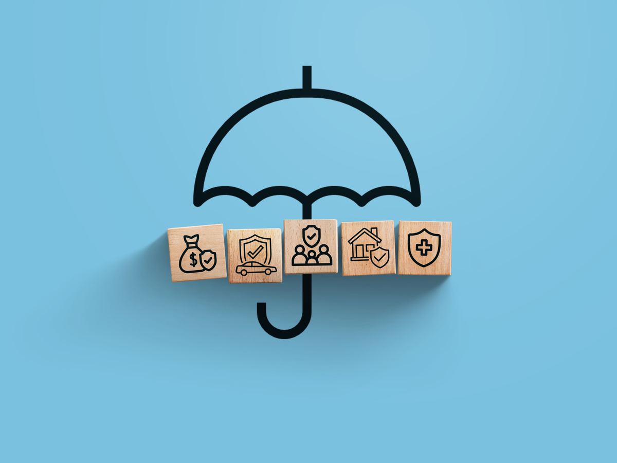 Parapluie protégeant des cubes représentant santé, famille et budget